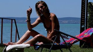 Eve sensually smoking 120's by the lake while sunbathing in slow motion 3