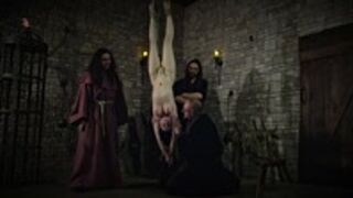 Mooin Witch – The exhausted milkmaid is pulled upside down to the ceiling with weights at her wrists to be tormented and interrogated further and to see milk flowing