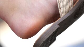 Dirty feet with slippers, foot fetish admiration, feet and shoes close-up.