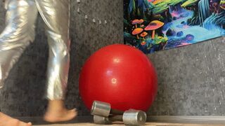 jumping on red gymball in silver costume