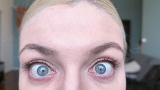 Blonde girl stares at you with her natural sky blue eyes