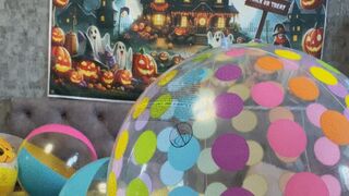 girl in pink dress riding on beachballs