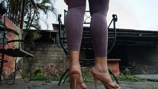 A woman sitting with big legs crossed and high heels dangling from her feet (2)