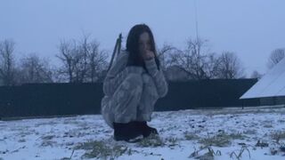 Frozen helpless girl on the snow trying to keep warm