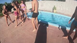 Tug-of-war between women and men next to a pool