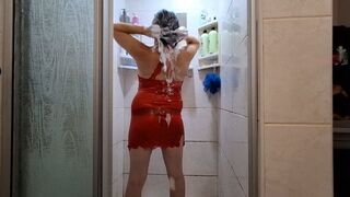 Hair washing in shower while wearing a red see through silk dress