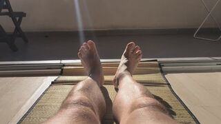 Sunbathing naked male legs.